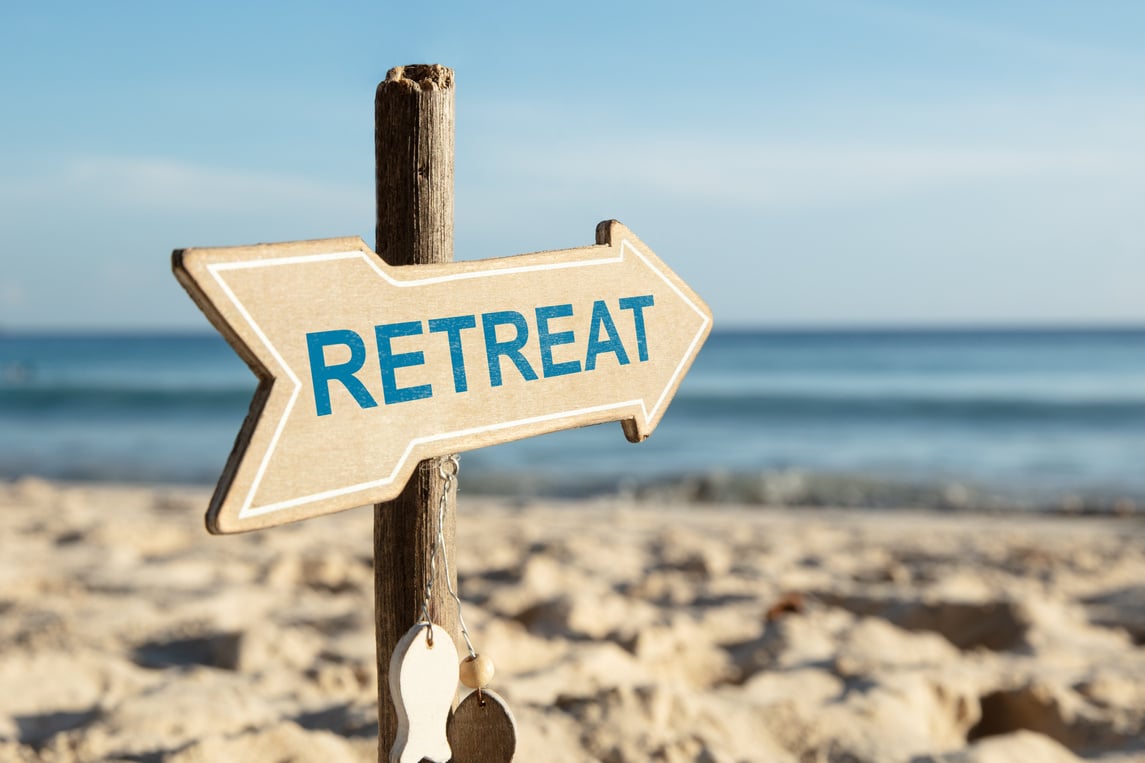 Retreat Arrow Sign On Beach